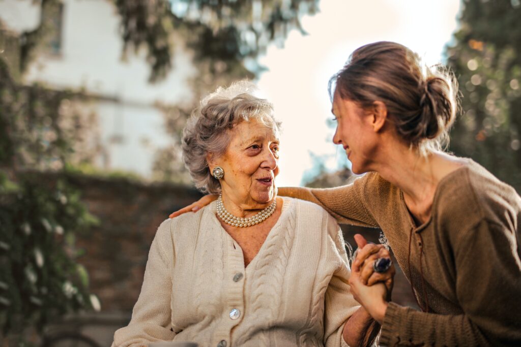 Younger woman and elderly woman spending time together interacting